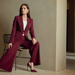 women's wearing marron color blazer is sitting on a stool in white background